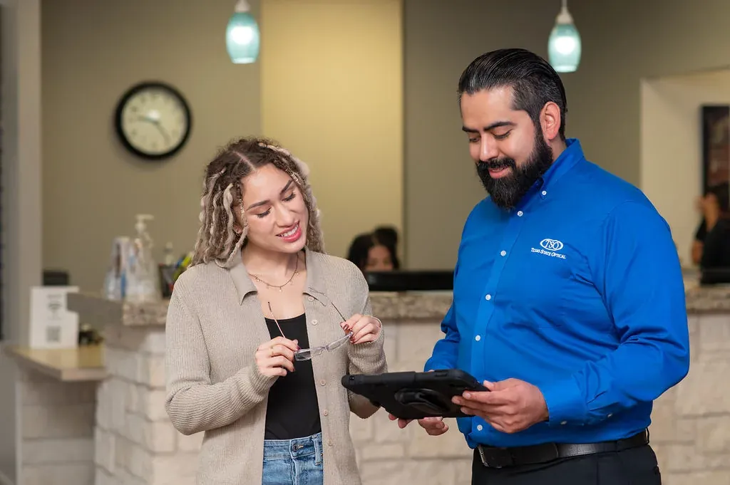 A TSO Kyle optician reviewing appointment details with a smiling patient at the front desk